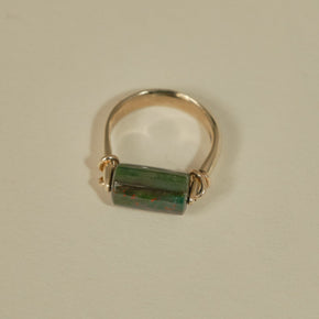 Gold bloodstone ring with a green stone on a beige background