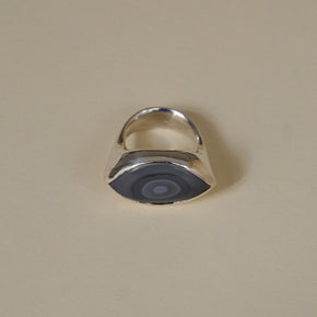 Silver ring with a blue stone on a beige background