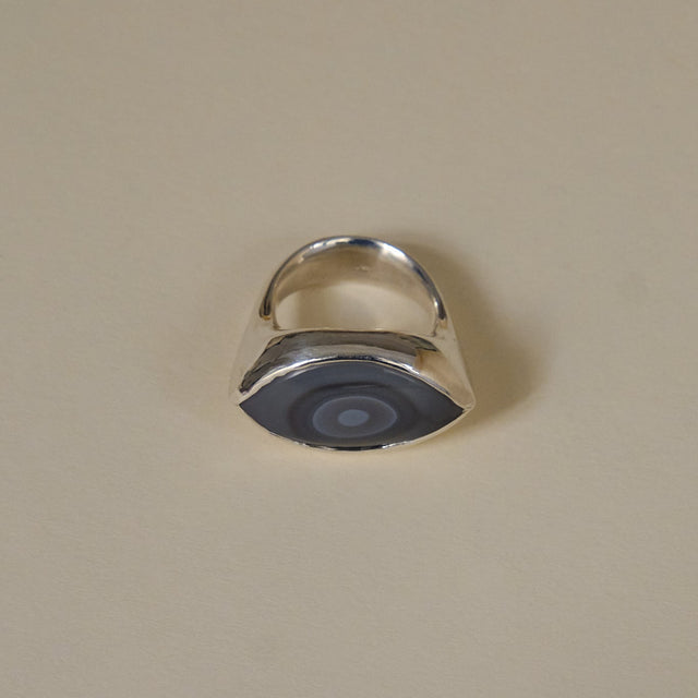 Silver ring with a blue stone on a beige background