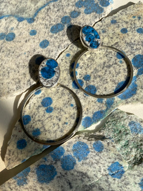 Handmade sterling silver K2 hoop earrings on rough lapidary material